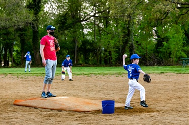 Coach And Child Playing Baseball