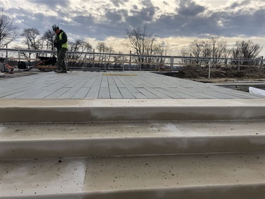 Paver installation at the top of the site stairs. These narrow pavers match pavers used in the Phase I design.