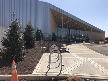 Front of building looking from the service yard. Bike racks, benches, infrastructure for lighting and signage.