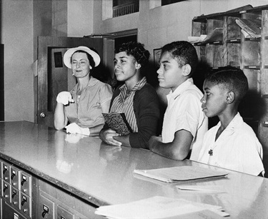 A.J.E. Davis, left, accompanies students Joyce Bailey, George Nelson and Leslie Hamm Jr., left to right, as they wait in the school office to see the principal of Stratford Jr. High School in Arlington, Va., Sept. 5, 1957. The principal, Claude Richmond, refused admission of the black students today as the fall term begins and told them they would have to attend Hoffman Boston School for Negroes where they had been assigned. (AP Photo)