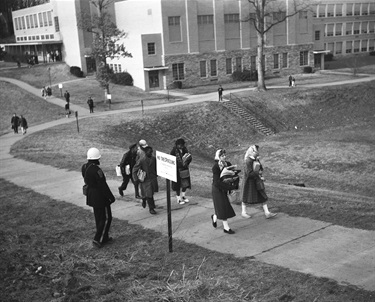 African American and white children walk past a policeman as they leave Stratford Junior High School in Arlington, Virginia Feb. 2, 1959, after the first day in integrate classes in Virginia. (AP Photo)