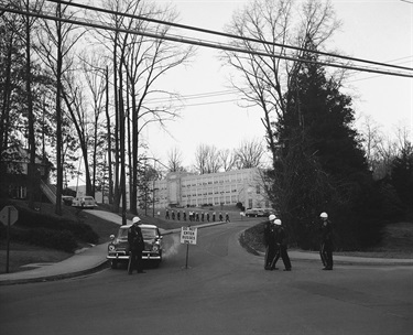 A heavy detail of police guards Stratford Junior High School in Arlington, Virginia Feb. 2, 1959. The Police were ready for a riot but wound up with almost nothing to do as Stratford became Virginia’s first racially mixed school. This view is at the rear of the big school before the start of classes. Row of police at center are walking to their assigned positions around the building. (AP Photo/JR)