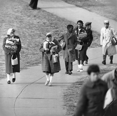 Four African-American children leave Stratford Junior High School in Arlington, Virginia on Feb. 2, 1959, after their first day at the previously all-white school. The African-American children, from left, are: Michael Jones, Gloria Thompson, Lance Newman and Ronald Deskins. They walked to the border of the school grounds where an auto waited for them. (AP Photo/Byron Rollins)