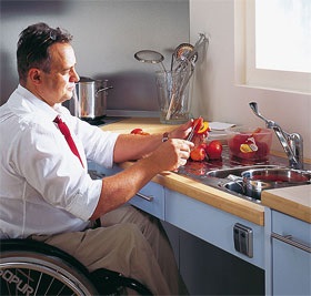 Man in wheelchair washing dishes