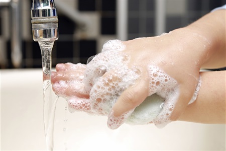 Soapy hands of little child hand-washing in the sink.