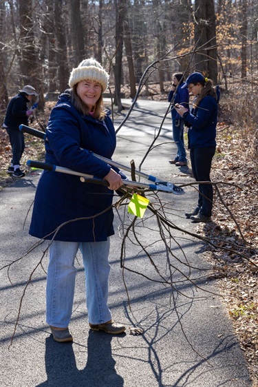 Smiling volunteer holds cut branches