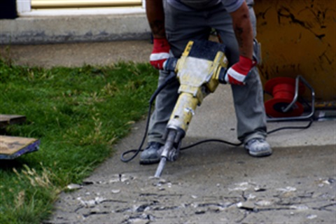 Person jack hammering a pavement