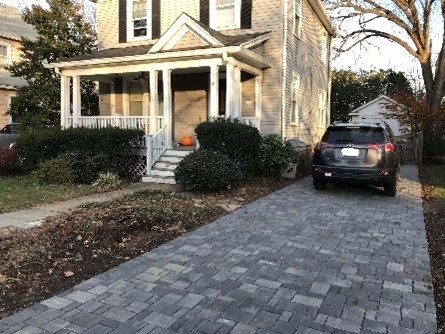 A house with a car parked on a completed permeable driveway.