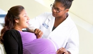 Photo of pregnant person with health care provider