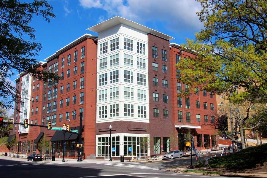 exterior of multi level building coloured red with large strip of white and windows in center