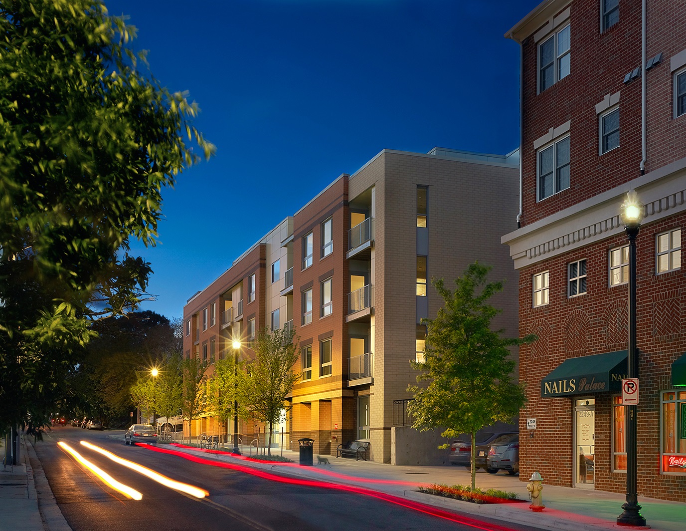 multi level sandstone buildings, photograph taken at dusk with flashes of car lights