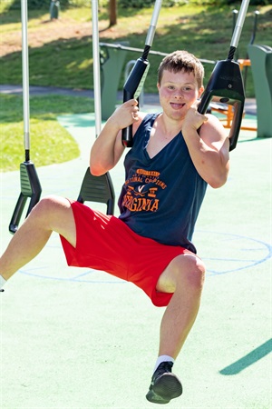 Young man using outdoor workout equipment